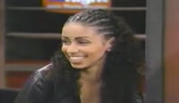 a woman in a leather jacket smiling on a television show