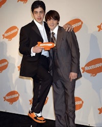 two young men in suits posing for a picture