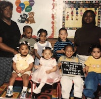 a group of children posing for a photo in front of a sign